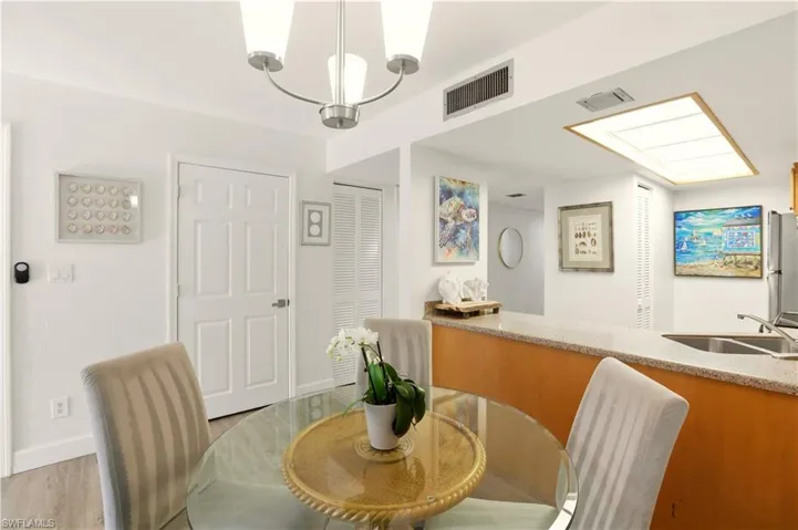 Dining room with wood finished floors and a chandelier