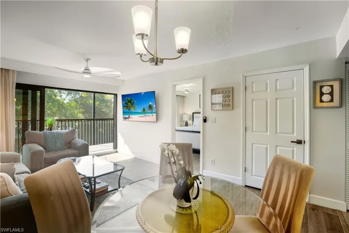 Living area featuring ceiling fan, wood finished floors, and suspended lighting