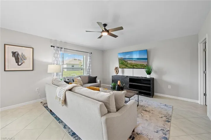 Living area with light tile patterned floors and ceiling fan
