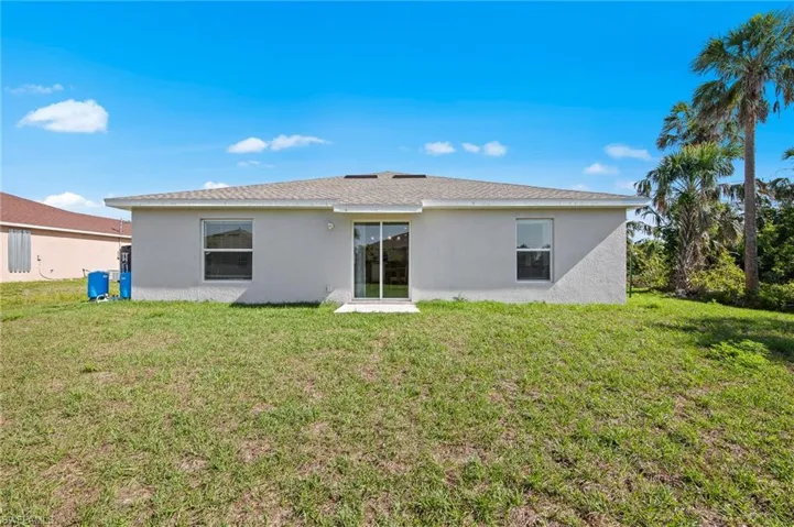 Back of property featuring stucco siding and a yard