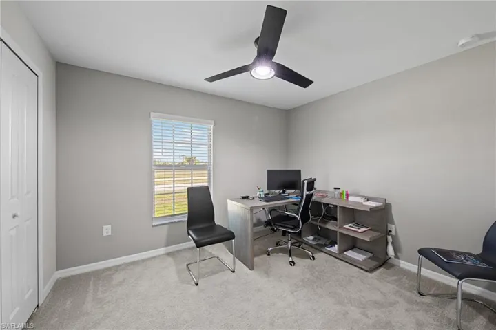 Home office with carpet and ceiling fan