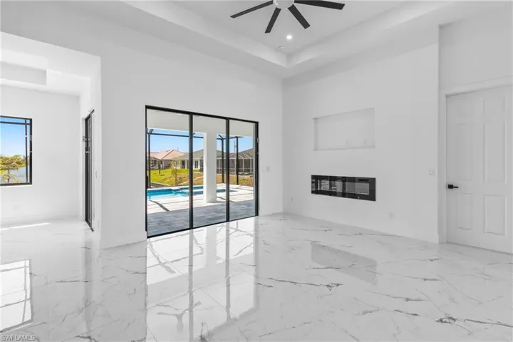 Living Room Boasts beautiful fireplace, tray ceiling with recessed lights