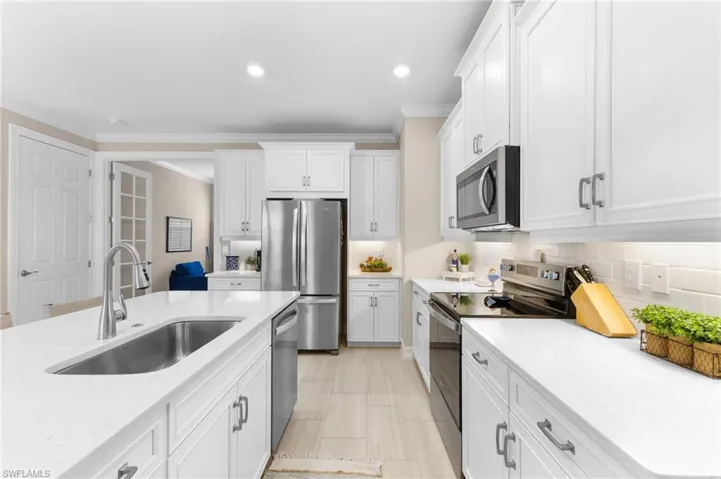 Kitchen featuring white cabinetry, tasteful backsplash, appliances with stainless steel finishes, and sink