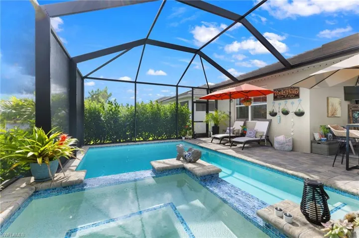 View of swimming pool with a patio area, an in ground hot tub, and a lanai