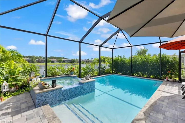 View of pool featuring a patio area, an in ground hot tub, and glass enclosure