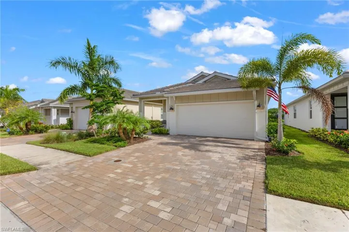 Single story home with a garage and a front lawn