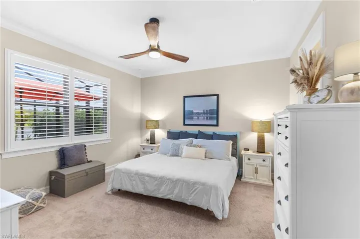 Carpeted bedroom with ornamental molding and ceiling fan