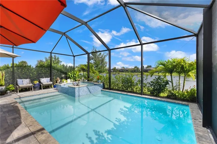 View of pool with an in ground hot tub, a lanai, and a patio area