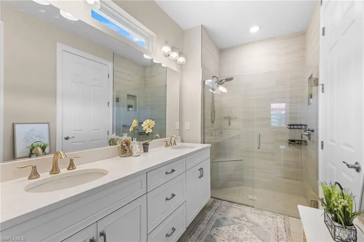 Bathroom featuring walk in shower and double sink vanity