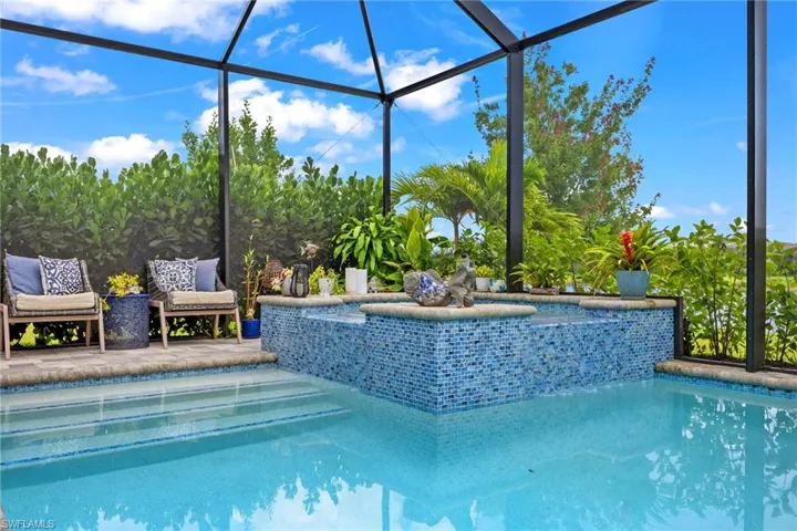 View of swimming pool featuring glass enclosure