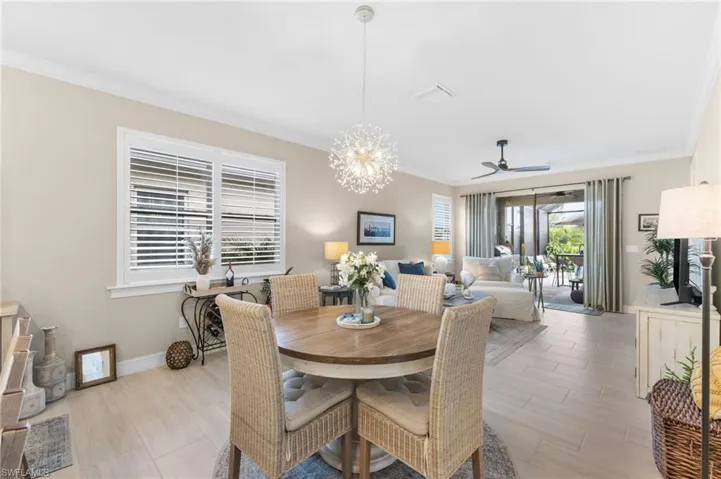 Dining room featuring ceiling fan with notable chandelier and ornamental molding