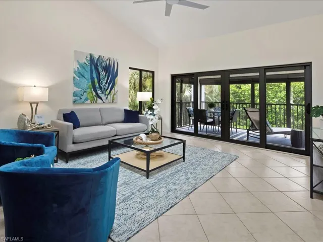 Living room with plenty of natural light, light tile patterned floors, and high vaulted ceiling