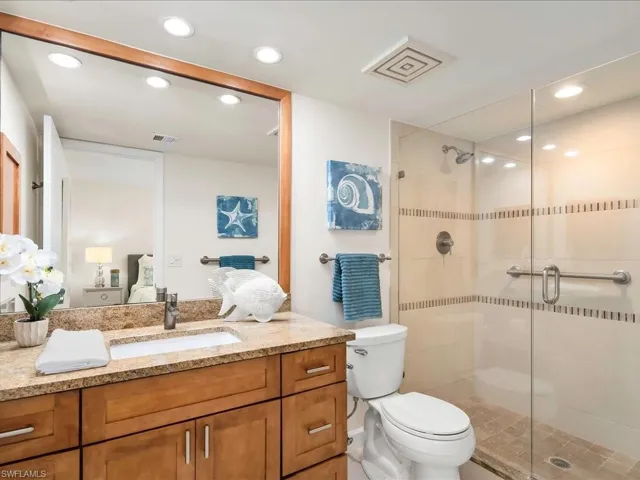 Ensuite bathroom with a shower stall, vanity, and recessed lighting