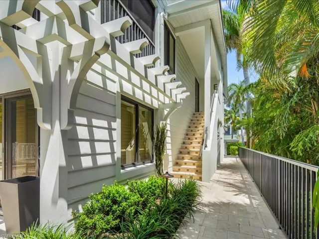 View of side of home with stairs and a pergola