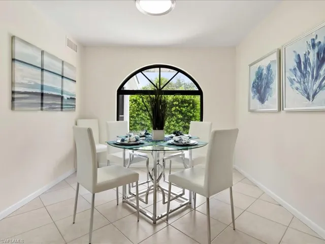 Dining area with light tile patterned floors and baseboards