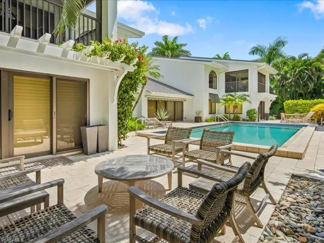 Outdoor pool with a balcony and a patio area