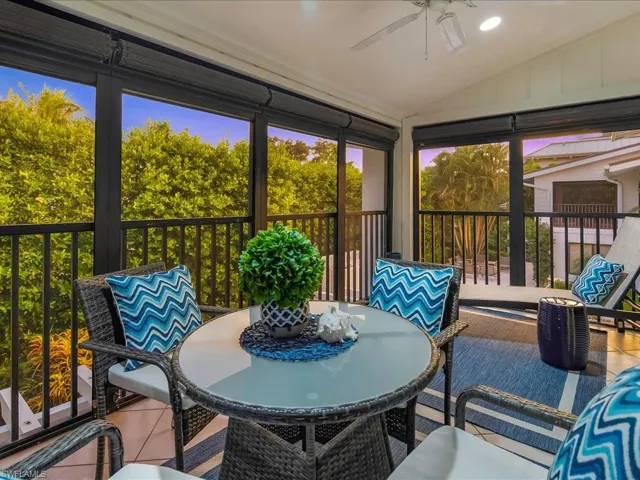 Sunroom with lofted ceiling, ceiling fan, a balcony, and outdoor dining area
