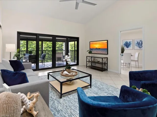 Living area with light tile patterned floors and high vaulted ceiling