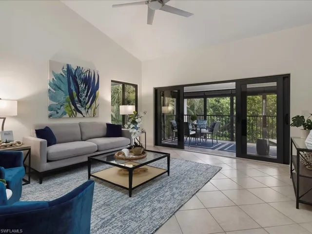 Living area with tile patterned floors and high vaulted ceiling