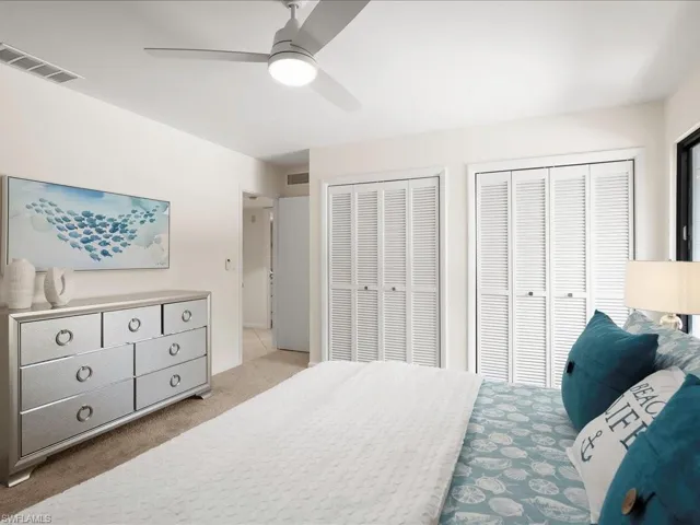 Bedroom featuring multiple closets, carpet, and a ceiling fan