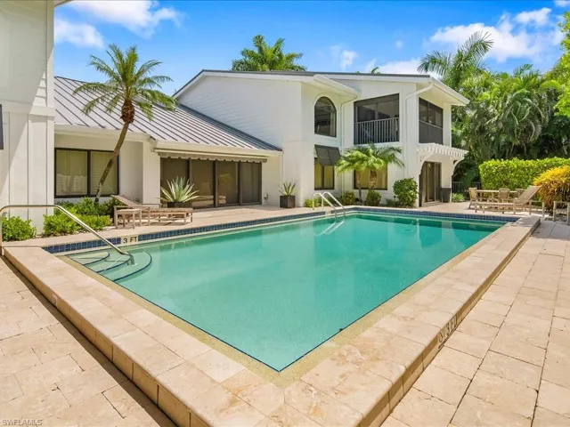 Community pool featuring a patio area, a balcony, and a sunroom