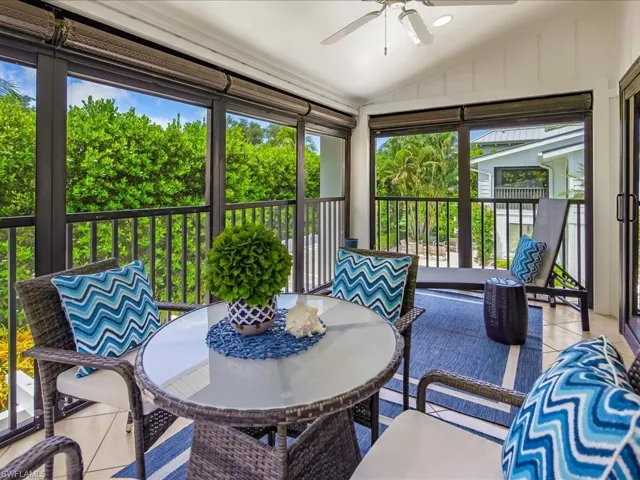 Sunroom with lofted ceiling, a ceiling fan, and a balcony