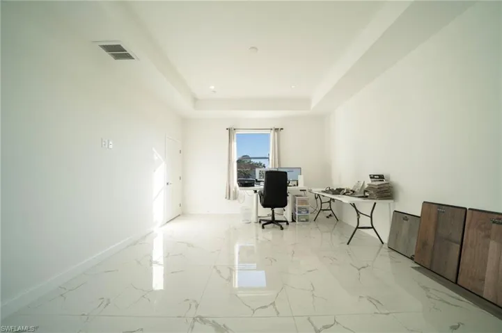 Office featuring a tray ceiling
