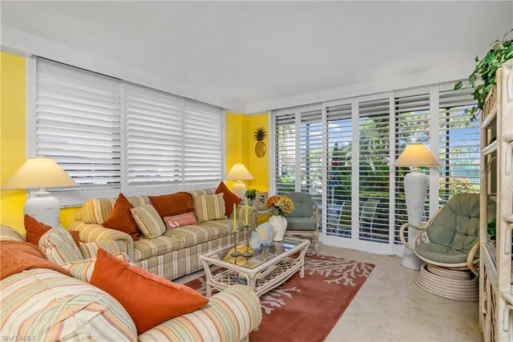Living room with ornamental molding and light tile patterned floors
