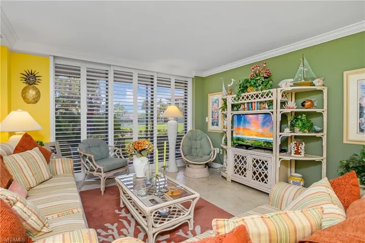 Tiled living room with a healthy amount of sunlight and ornamental molding