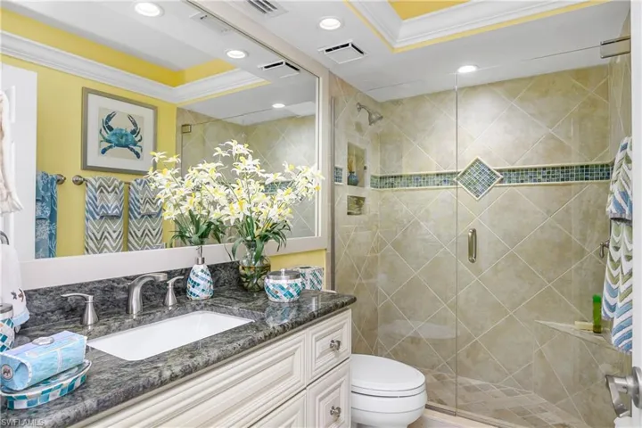 Bathroom featuring crown molding, toilet, and an enclosed shower
