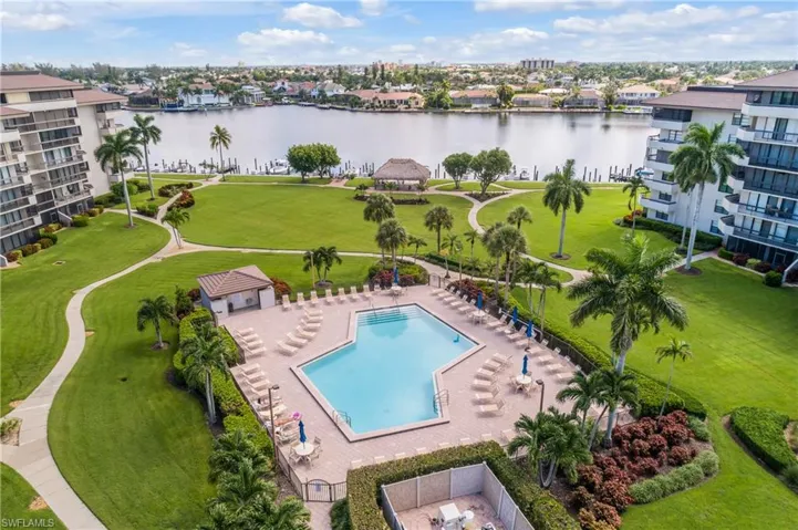 View of swimming pool with a water view and a yard