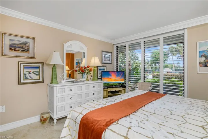 Bedroom with ornamental molding and light tile patterned floors