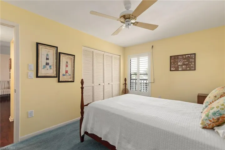 Bedroom with a closet, carpet, baseboards, and ceiling fan