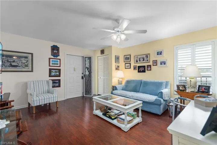 Living area featuring ceiling fan, wood finished floors, and baseboards