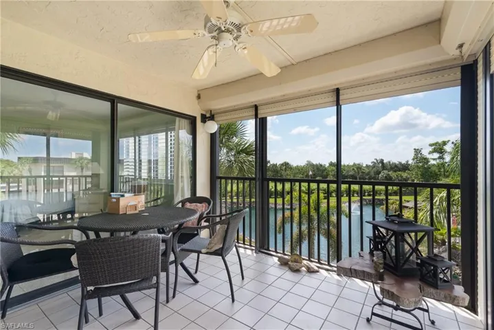 Sunroom with ceiling fan and a water view