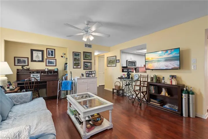 Living room featuring a ceiling fan, wood finished floors, and baseboards