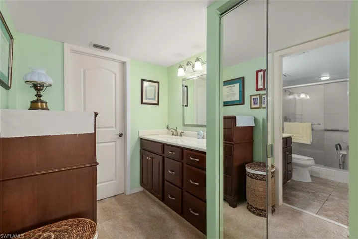 Bathroom featuring vanity, toilet, and a shower stall