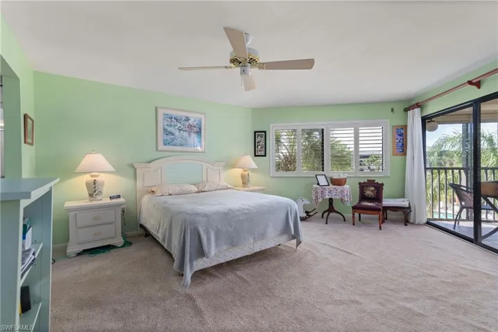 Carpeted bedroom featuring access to outside and a ceiling fan