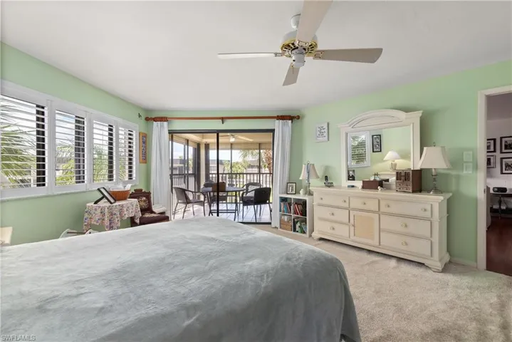 Bedroom featuring access to exterior, light colored carpet, and ceiling fan