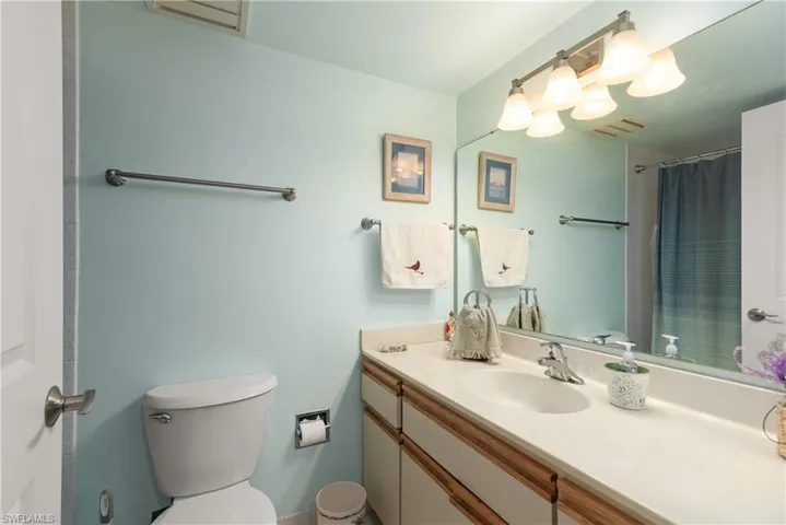 Full bath featuring vanity, toilet, and curtained shower