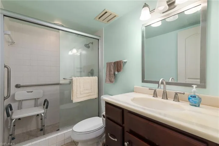 Bathroom with vanity, toilet, and a shower stall