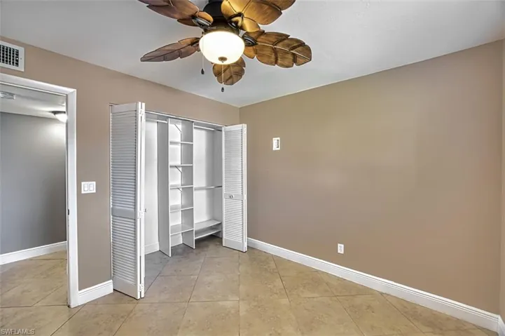 Guest bedroom with closet organizers tile floors