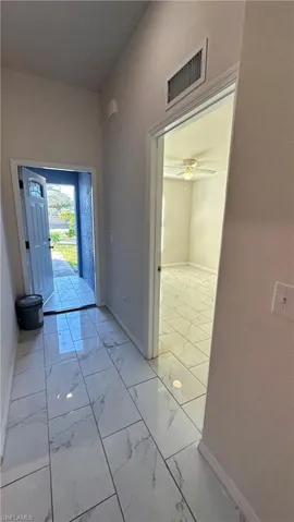 Entrance foyer with light marble finish flooring and ceiling fan