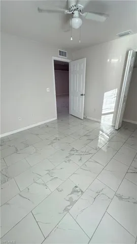 Unfurnished room featuring baseboards and a ceiling fan