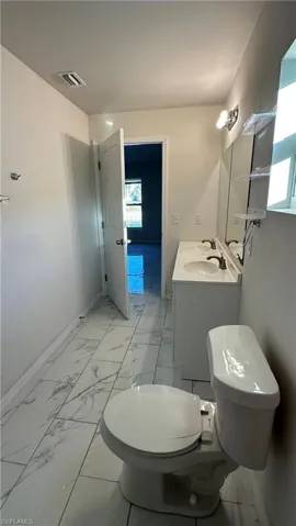 Half bathroom with vanity and light marble finish flooring