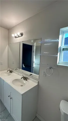 Full bath with double vanity and toilet