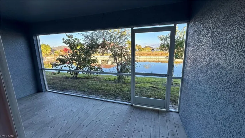 Entryway with a textured wall, wood finished floors, and a water view