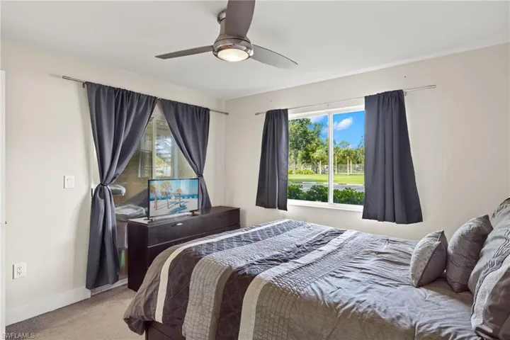 Carpeted bedroom featuring ceiling fan