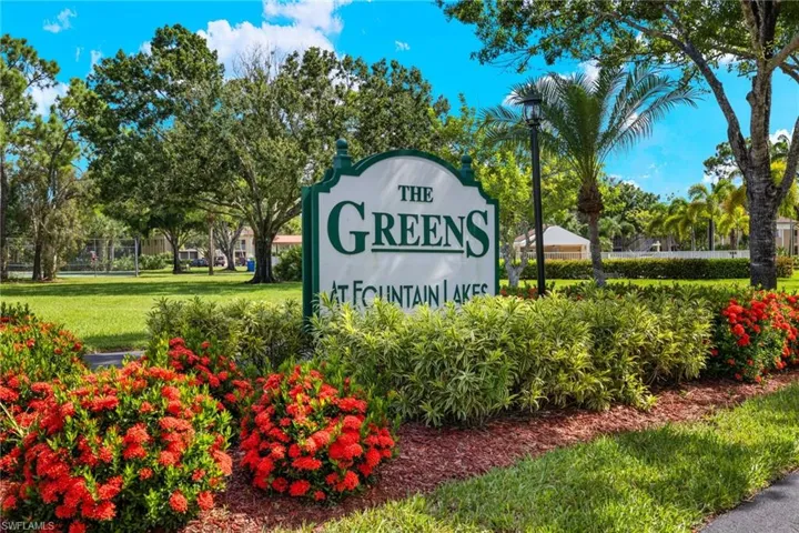 Community / neighborhood sign featuring a yard