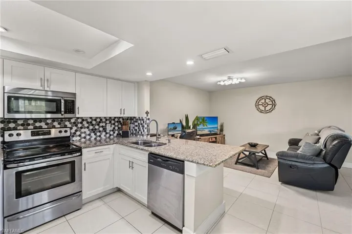 Kitchen featuring tasteful backsplash, appliances with stainless steel finishes, sink, and kitchen peninsula